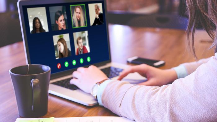 En person sitter vid en bärbardator och deltar i ett digitaltmöte.