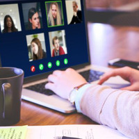 En person sitter vid en bärbardator och deltar i ett digitaltmöte.