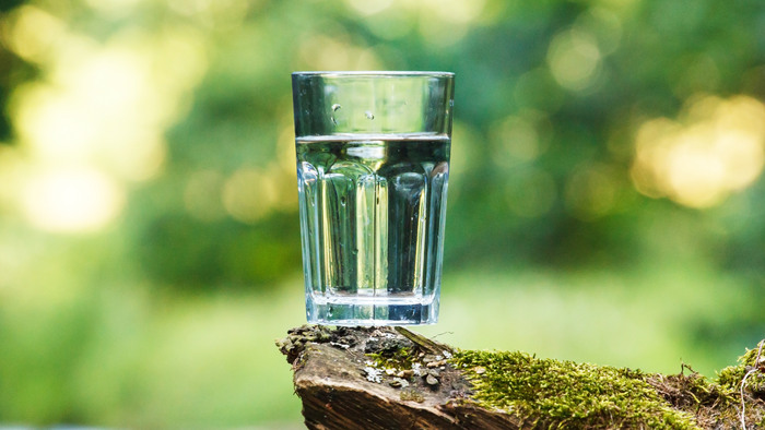 Vatten i ett glas med grön bakgrund