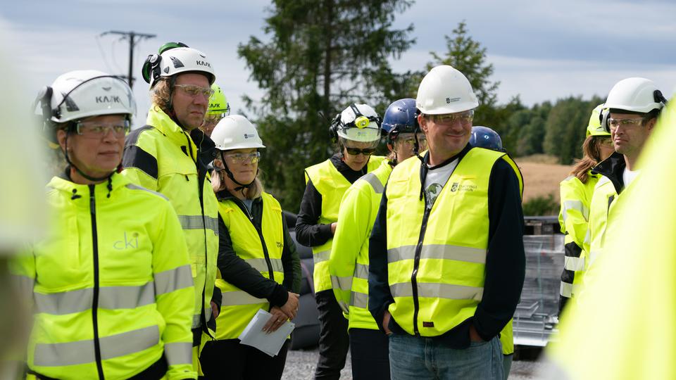 Grupp av människor står klädda i säkerhetsväst