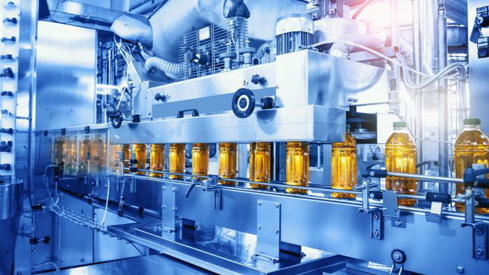 Beverage factory, Conveyor belt with juice in bottles, Industrial Interior in blue color, food and drink production line process.