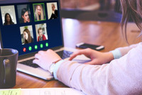 En person sitter vid en bärbardator och deltar i ett digitaltmöte.