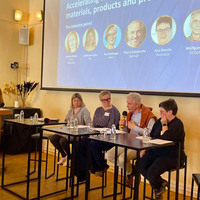 A panel of speakers sitting on a podium