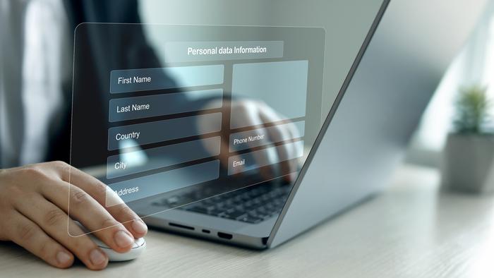 En person sitter vid en dator och registerar sina uppgifter